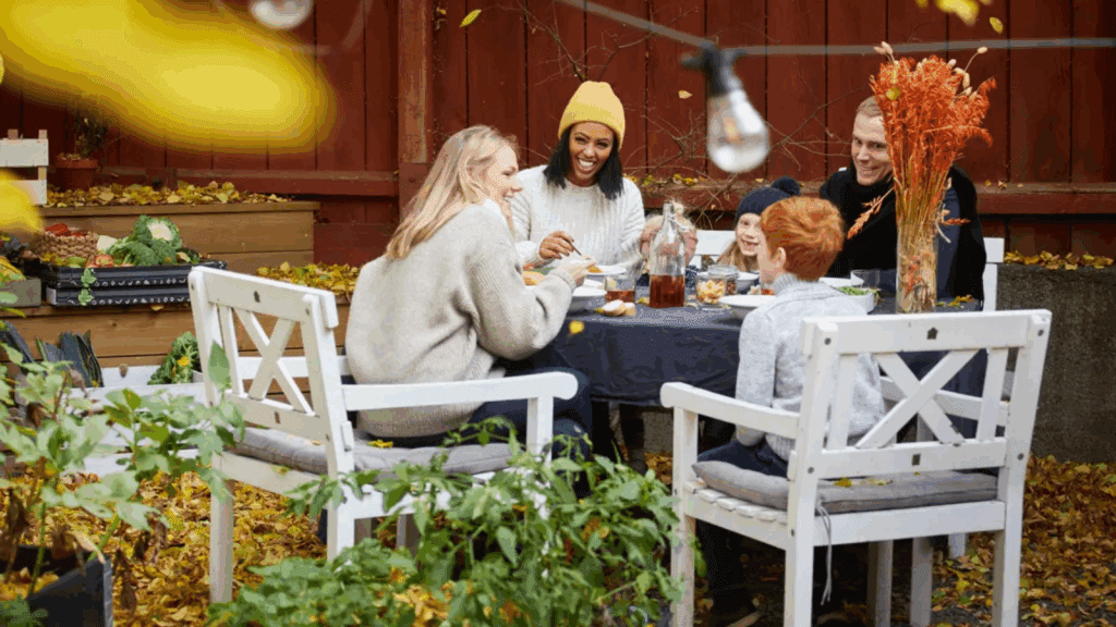 Family enjoying outdoor fall meal with autumn decor