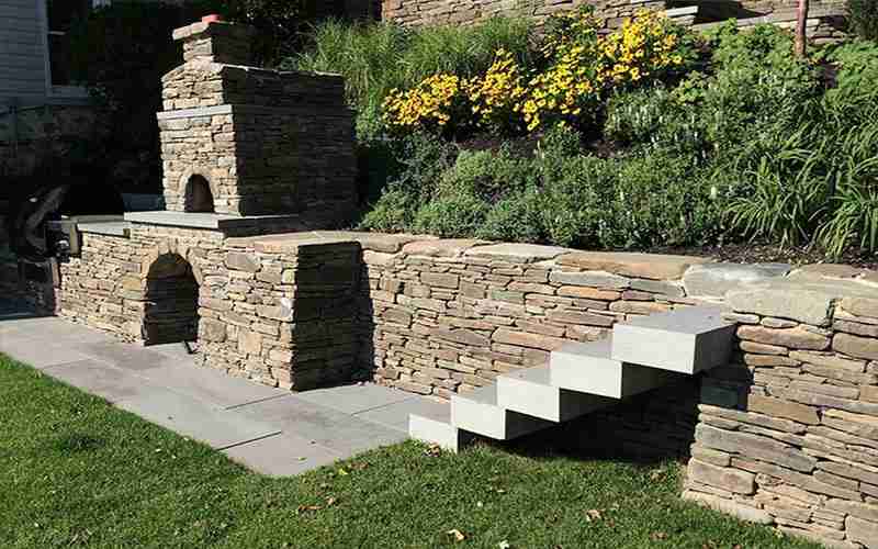 Outdoor kitchen with pizza oven retaining wall and retain wall installers near me